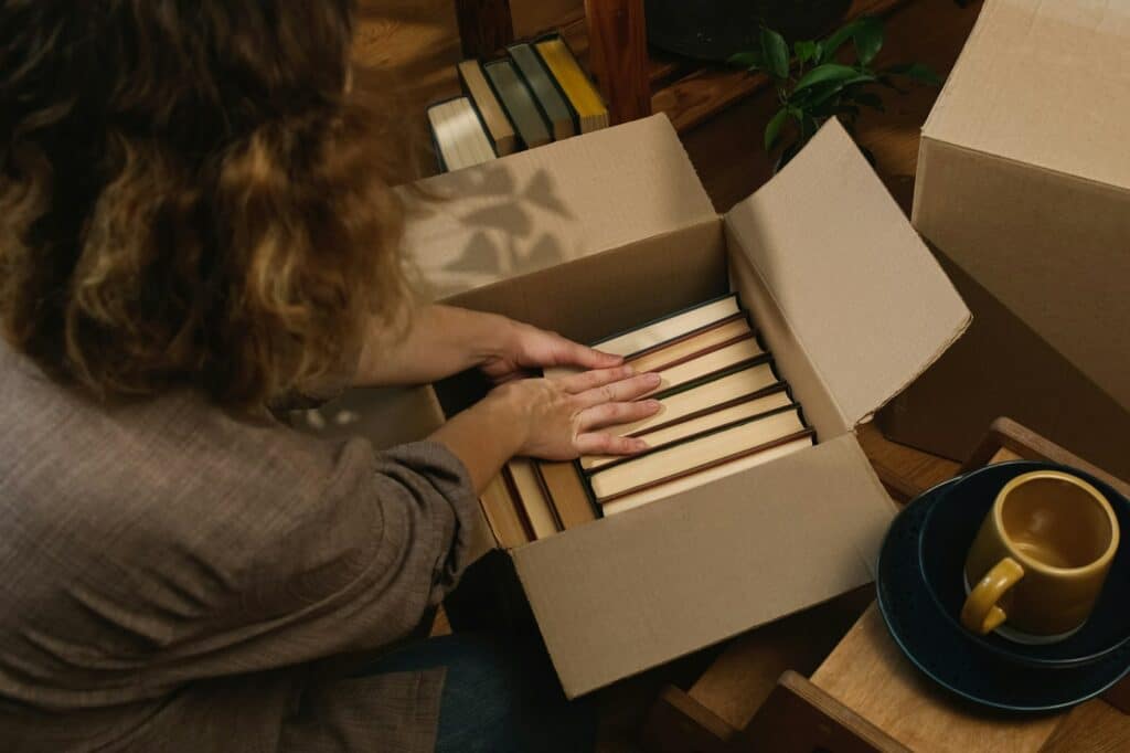 Why You Need High-Quality Moving and Packing Materials 3 Relocation, movement. Young woman packing books in moving box.