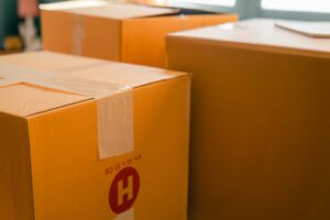 Sealed moving boxes stacked by a sunny window, ready for a military PCS move